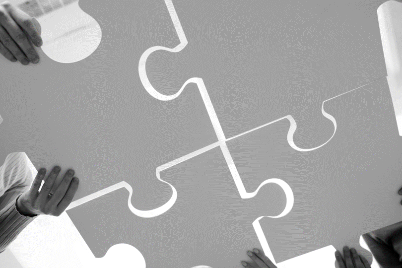 Puzzleteile, die von Menschen zusammengefügt werden. Puzzleteile, die von Menschen zusammengefügt werden.