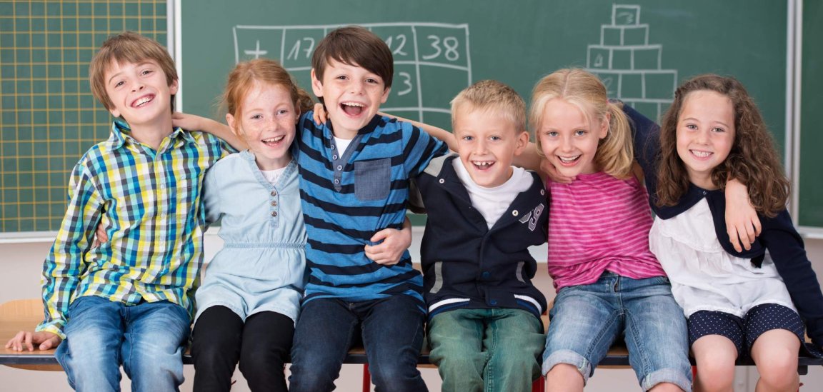Gruppe von Kindern, vor einer Schultafel.