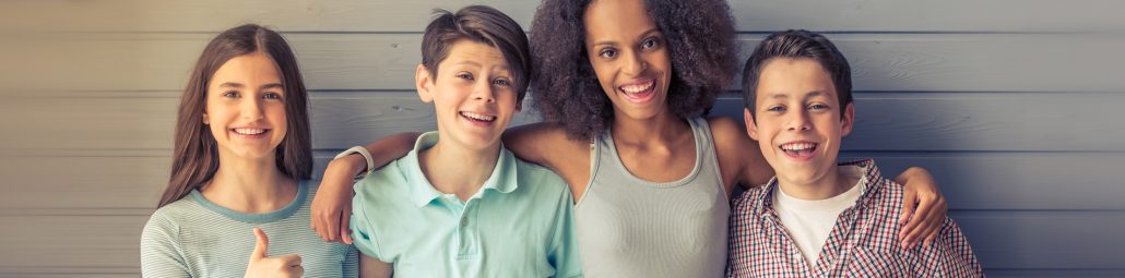 Gruppe von Kindern, die nebeneinander stehen und sich freuen.